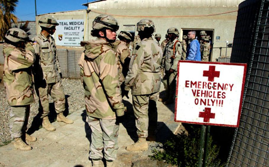 Pfc. Amy Bigger of Company A, 203rd Forward Support Battalion, and other soldiers wait for casualties shortly after Wednesday morning&#39;s car-bomb blast outside the gate of Forward Operating Base Warhorse in Baqouba, Iraq. The explosions killed four Iraqi soldiers and wounded 17.