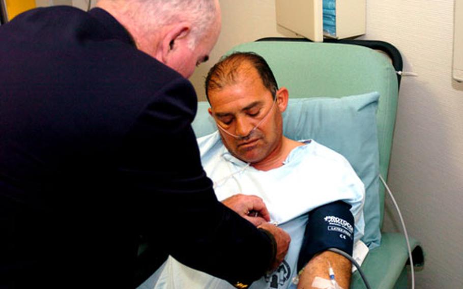 Army Secretary Francis J. Harvey awards the Purple Heart to Sgt. 1st Class Carlos Chavez Saturday at Landstuhl Regional Medical Center in Germany. Chavez, a Tennessee National Guard member, operated with the 278th Military Intelligence Battalion in Iraq. He was injured during a mortar attack.