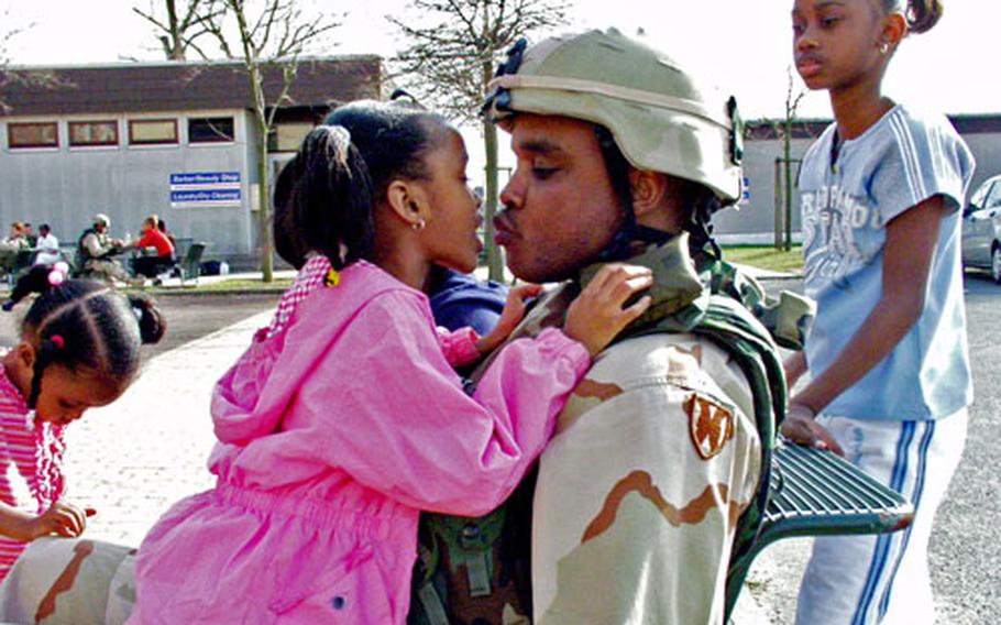Spc. Jamaal Simmons with the 69th Transportation Company kisses his 6-year-old daughter, Daijhsha, goodbye on Monday. Simmons and about 80 others from his unit deployed Monday for a yearlong Afghanistan tour.