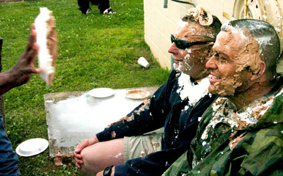 Senior Chief Petty Officer Robert Moons. left, and Petty Officer 1st Class Daniel Mckee take a pie in the face at Naval Mobile Construction Battalion 40&#39;s Over-the-Hump party on Camp Shields, Okinawa. The unit is celebrating the halfway point of its deployment to Okinawa.