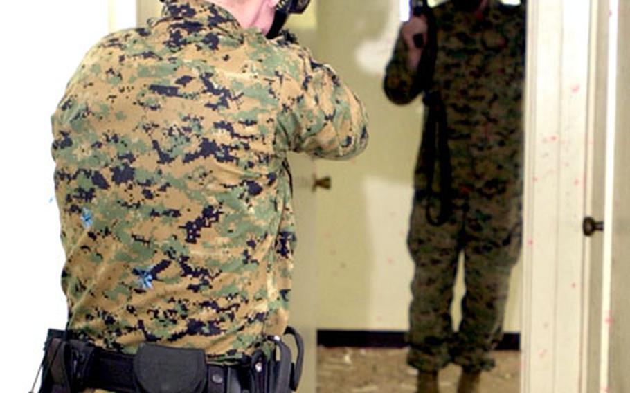 A Marine MP keeps his weapon on an armed suspect who fired on him during Tuesday&#39;s training in the old Sada Housing.