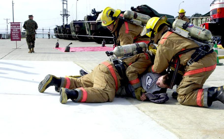 Marine Corps Base firefighters on Camp Schwab subdue a "victim" in Thursday&#39;s mass casualty drill.