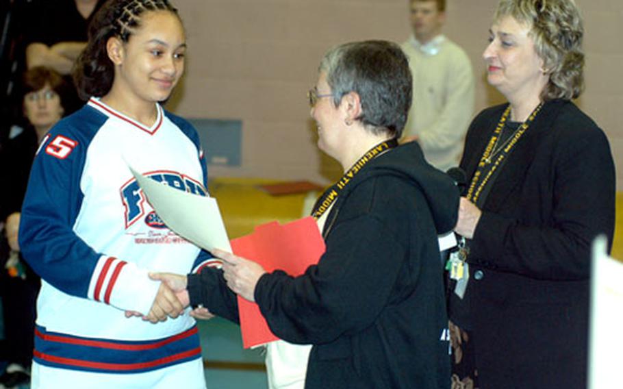 Briana Barrs, left, receives a certificate from Jannett Klinke, principal of Lakenheath Middle School, for helping an ill classmate. Students are participating in a Junior Wingman program, a program encouraging students to look out each other.