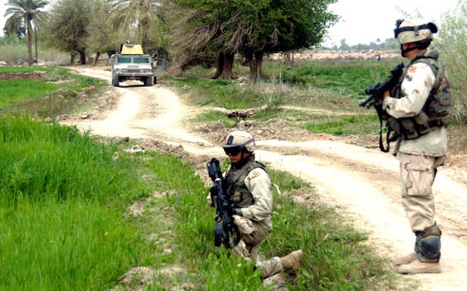 Soldiers from Troop A, 6th Squadron, 8th Cavalry Regiment, 4th Brigade at Forward Operating Base Falcon, Iraq, help secure a dirt road during a patrol in a rural village south of Baghdad.