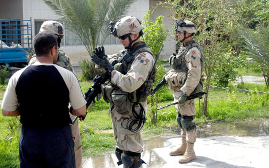 Sgt. 1st Class Tony Hillig, center, a platoon sergeant for Troop A, 6th Squadron, 8th Cavalry Regiment, 4th Brigade at Forward Operating Base Falcon, Iraq, questions an Iraqi man during a patrol in a rural village south of Baghdad.