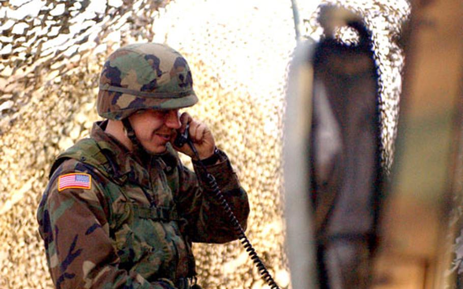 Spc. Justin Bates, a wire system installer with the 304th Signal Battalion, 1st Signal Brigade, conducts a voice check on a tactical phone.