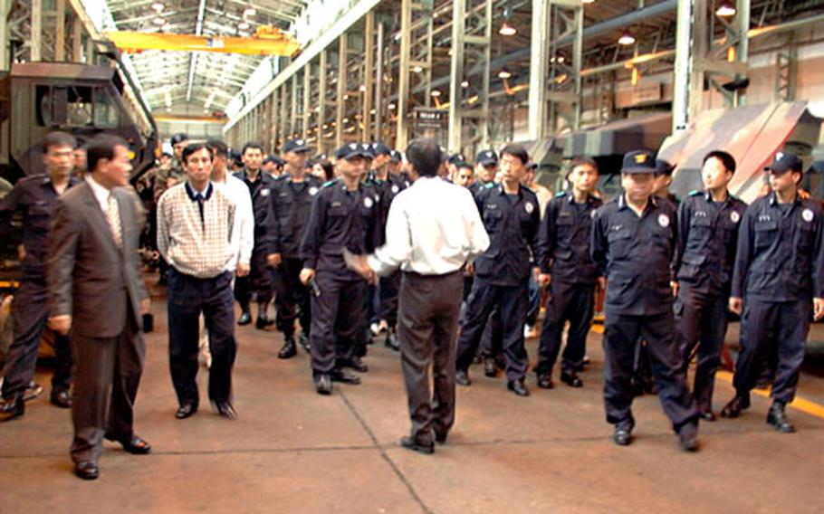 Korean National Police officers tour a maintenance shed at Camp Carroll in Waegwan, South Korea, in April 2003. Base officials were to host a visit Wednesday by the KNP’s newly assigned police chief for the Camp Carroll region.