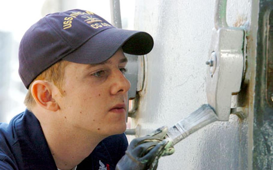 Petty Officer 2nd Class, from OI Division, applies paint to help ready the USS Vincennes for decommissioning.