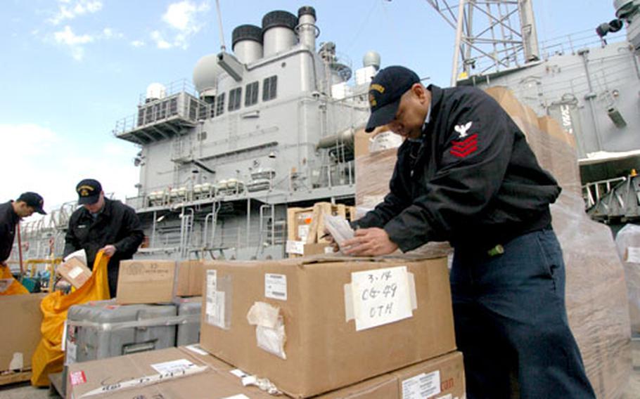 Petty Officer 1st Class Bernard Abanto, right, from S-1 Division, checks receipts for parts while other sailors from the USS Vincennes pick up their supplies on the pier at Yokosuka Naval Base. Abanto will transfer to the USS Kitty Hawk after the ship’s decommissioning.