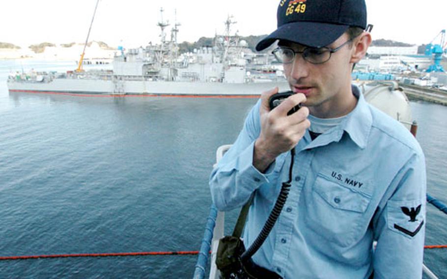 Petty Officer 3rd Class Patrick Iliff, from CG Division, keeps an eye out for waterborne threats while standing topside rover watch on the USS Vincennes. Iliff will transfer to the USS Chancelorsville after the decommissioning.