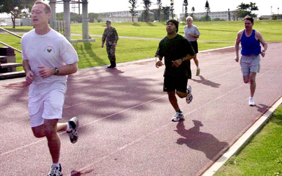 Members of the 18th Wing Headquarters staff, including Wing Commander Gen. Jan-Marc Jouas, run 1.5 miles as part of their year-old physical training test at Kadena Air Base.