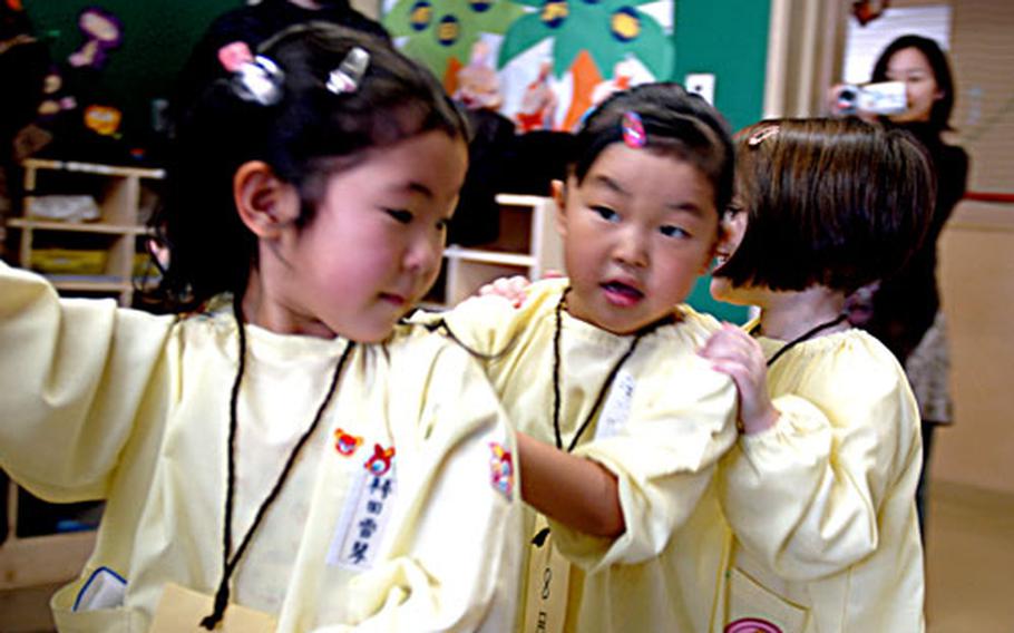 Julia Sanders, center, and Madaline Stephens, play a game during a recent Parent&#39;s Day at Daiichi Yochien, a private, Japanese kindergarten in Misawa city in northern Japan. Julia and Madaline are among a handful of American students attending the school. Their parents, who either live or work at Misawa Air Base, chose an off-base preschool program for the language and cultural experience.