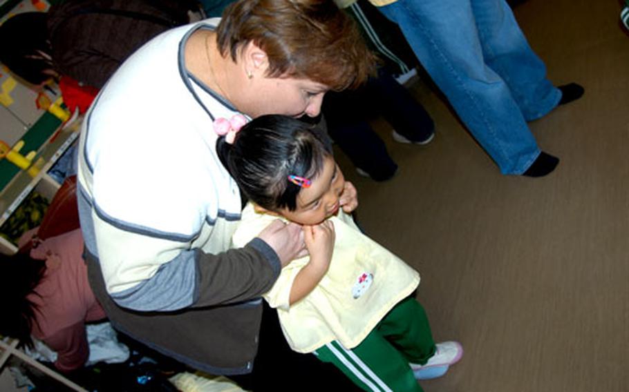 Heather Sanders, a Department of Defense Dependents School teacher at Misawa Air Base, Japan, hugs her daughter, Julia, 5, during a recent Parent&#39;s Day at private kindergarten Daiichi Yochien in Misawa city. Sanders chose Daiichi over on-base preschool for the language and cultural exposure.