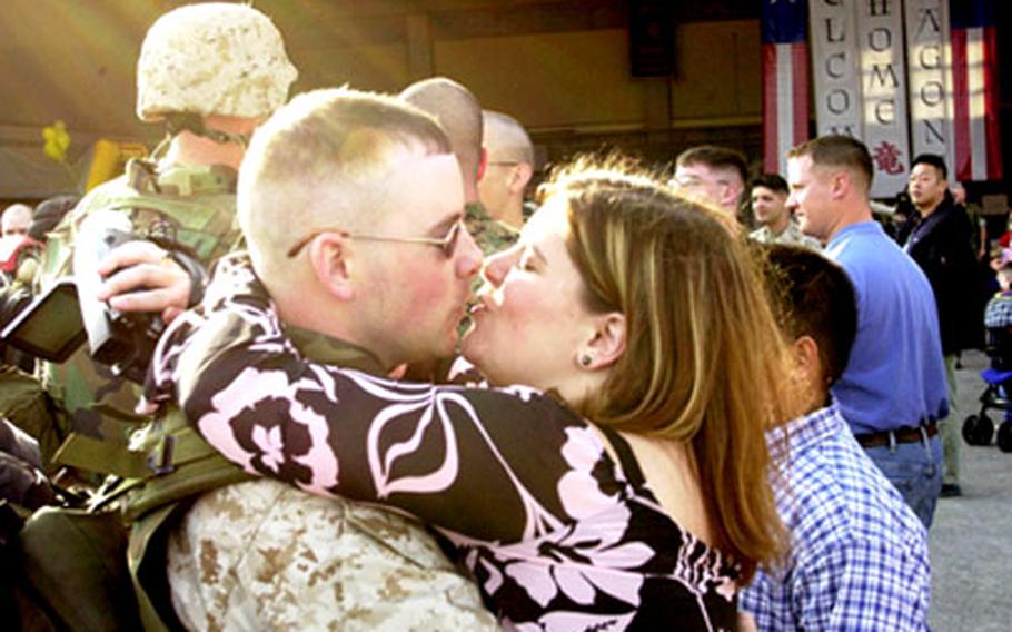 Tanya Schultz offers a kiss to welcome home her husband, Sgt. Dustin Schultz.