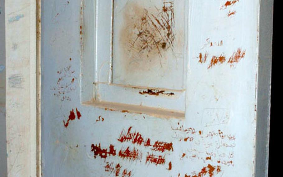 Arabic phrases are carved into cell doors and walls inside the prison.