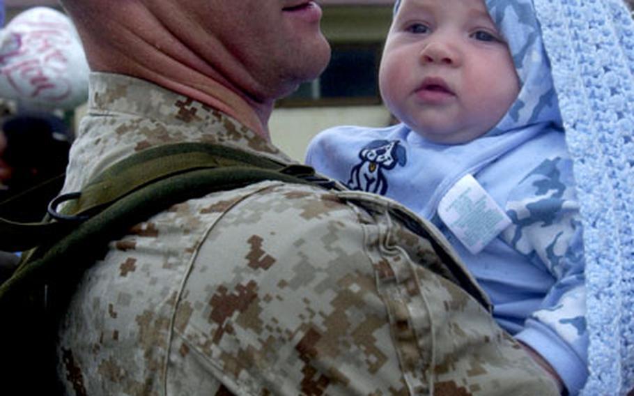 Sgt. Erik Toney gets his first look at his four-month-old son, Christian, at White Beach Naval Facility, Okinawa, after coming home Saturday after a tour in Iraq.