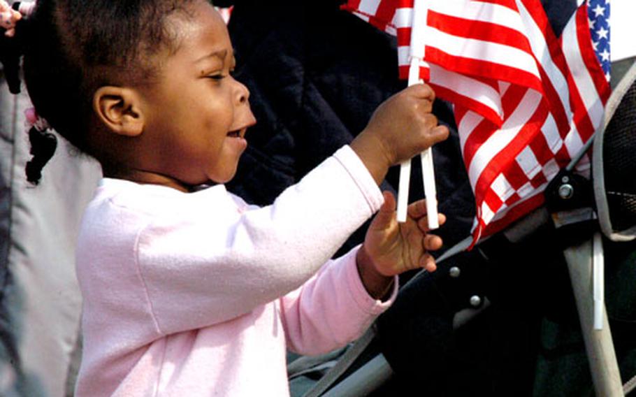 Hannah Eady, 2, waves a flag Saturday morning before the start of the Walk for Fallen Heroes on Yongsan Garrison in Seoul.