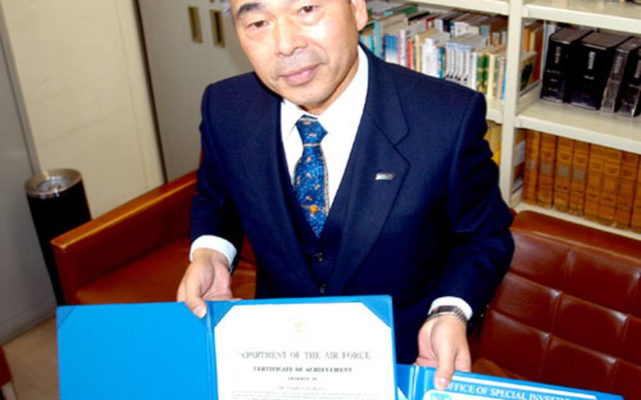 Yukio Yamahata displays certificates of appreciation he received from U.S. Forces Japan and 5th Air Force officials for his work as a liaison officer between Misawa Air Base and Misawa police officials.
