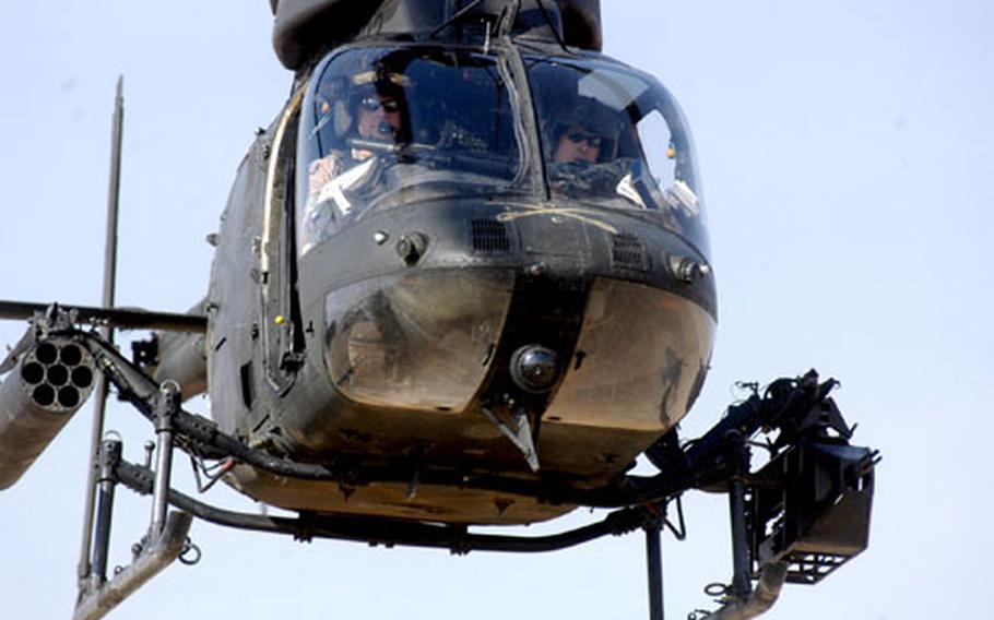 Two pilots take off Thursday in their Kiowa OH-58D helicopter from forward Operating Base MacKenzie in Ad-Daluiyah, Iraq. To the pilots’ left is a .50-caliber machine gun; to their right is the rocket launcher.