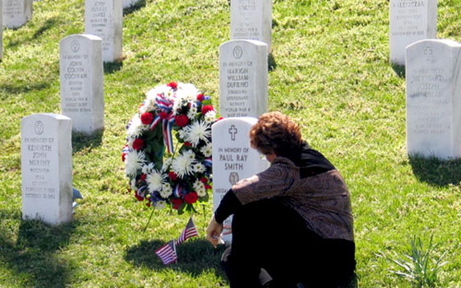 Birgit Smith, the widow of Sgt. 1st Class Paul R. Smith, breaks down in tears in front of the memorial site of her husband. The marker was dedicated in a ceremony at Arlington National Cemetery, Va., on Tuesday, the day after Smith was posthumously awarded the Medal of Honor.