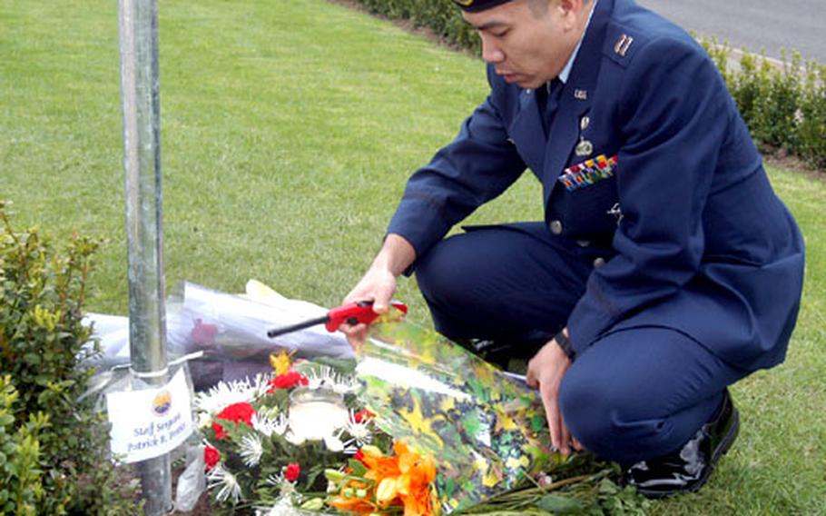Capt. Emmanuel Guevarra, of the Security Forces Flight, 423rd Air Base Squadron at RAF ALconbury, England, prepares to light a candle Wednesday at Remembrance Park on RAF Mildenhall. Guevarra had just stood a vigil at the park in memory of nine airmen from the base who died last week when their aircraft crashed in Albania.