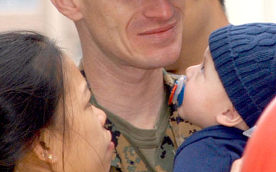 Gunnery Sgt. Randall Nace holds his wife, Jennifer, and son Robert on Wednesday during the homecoming celebration.