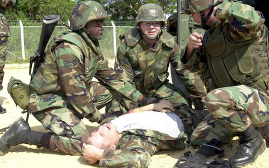Airmen attend to a servicemember "wounded" during a simulated rocket attack.
