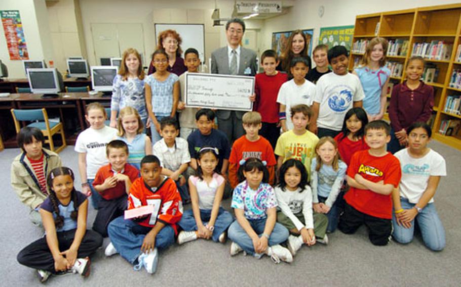 The Sullivans Elementary School student council and Parent Teachers Organization Board present United Nations Children’s Fund representative Tatsuru Mikami, center, a check for $6,052.86 on Wednesday at Yokosuka Naval Base, Japan. The check was the result of fund-raisers to help children in South Asia affected by the tsunami.