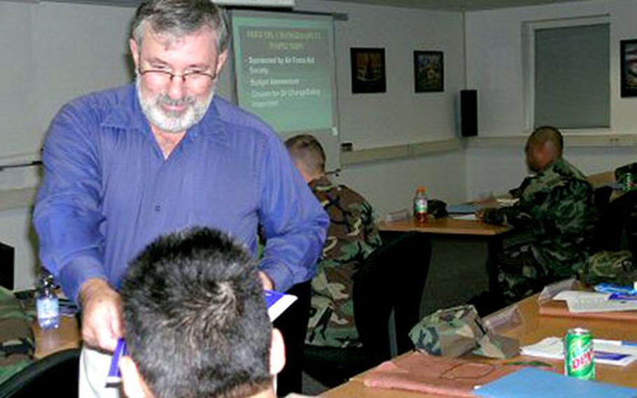 Bill Triplett, a financial counselor with the Family Support Center at Spangdahlem Air Base, Germany, hands out material during a financial seminar for airmen. Triplett has warned servicemembers of the pitfalls with securing loans at off-base providers.
