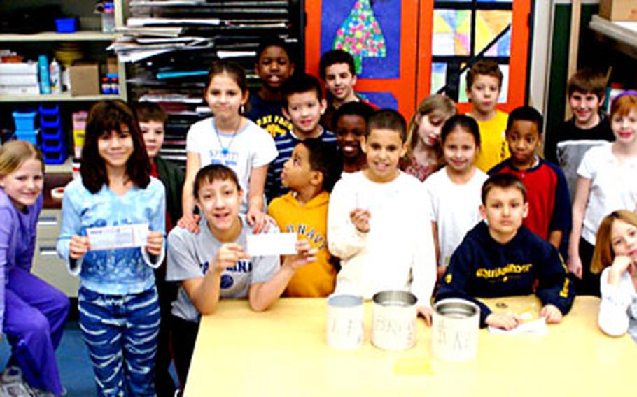 Members of the student council at Patrick Henry Elementary in Heidelberg, Germany, pose with checks and some of the cans they used to collect change in a fund drive that raised over $1,500.