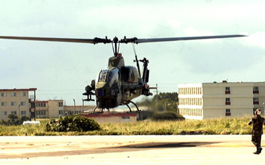 An AH-1W Cobra is directed in for a landing at Marine Corps Air Station Futenma on Okinawa.