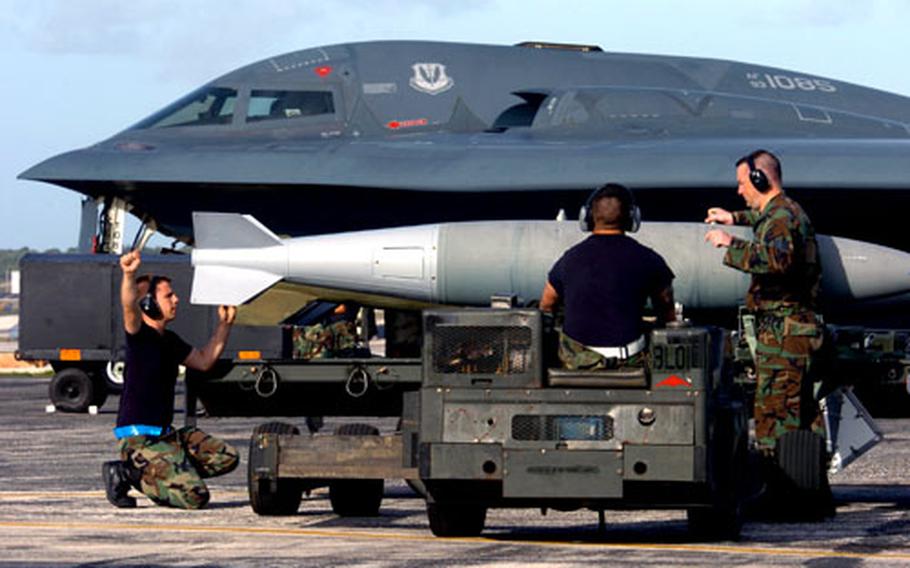 Weapons specialists from the 509th Aircraft Maintenance Squadron, Whiteman Air Force Base, Mo., prepare to load a BDU-56 bomb on a B-2 Spirit bomber at Andersen AFB, Guam.