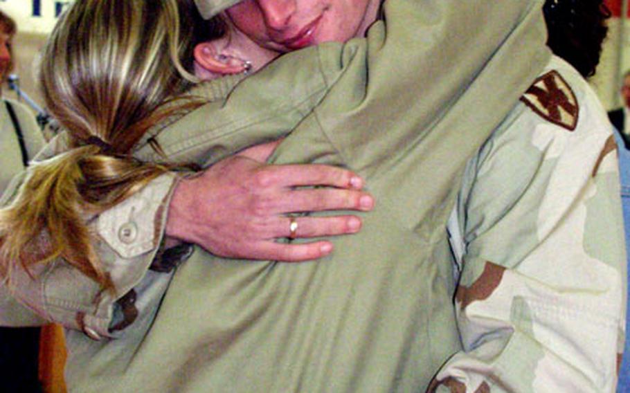Army Spc. Erik Parsons, of the 39th Transportation Battalion’s 618th Movement Control Team, hugs his wife, Rebecca, on Tuesday after returning home from a yearlong deployment to Afghanistan.