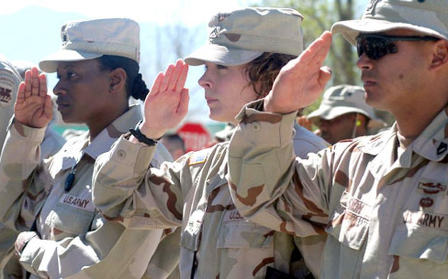 Soldiers salute during the playing of "Taps" at the memorial service at Bagram Air Base.