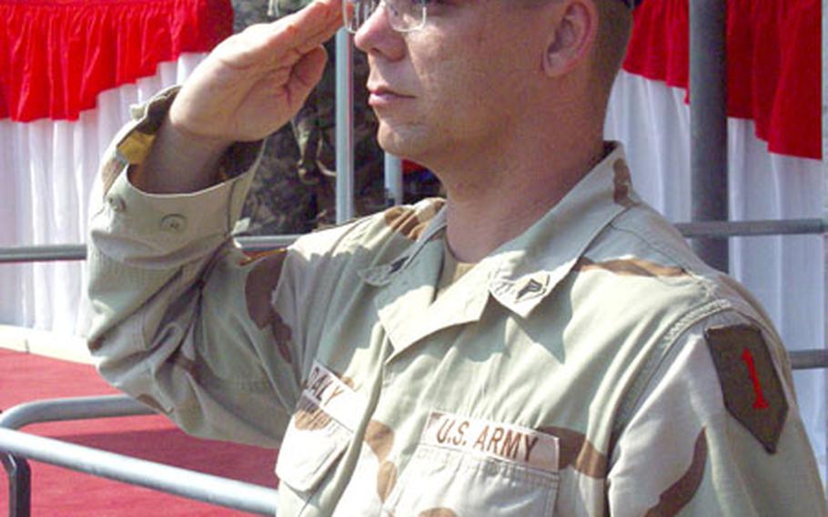 Sgt. Michael Daly of the 1st Infantry Division band salutes crisply during the national anthem Friday.