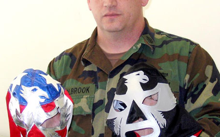 Senior Chief Petty Officer Glen Holbrook, a master-at-arms at Sasebo Naval Base&#39;s Security Division, shows two of the masks he&#39;s worn as a longtime professional wrestler. He started at age 20 in Georgia, and still wrestles as a "bad guy" in Japanese pro matches.