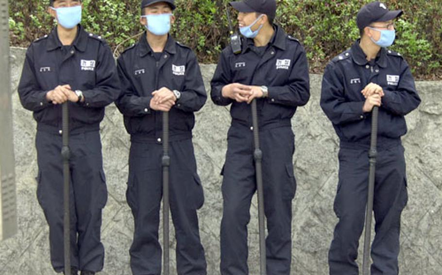 Korean National Police standing duty outside the U.S. Army&#39;s Yongsan Garrison in Seoul on Wednesday wear dust masks to protect themselves from the dust in the air.