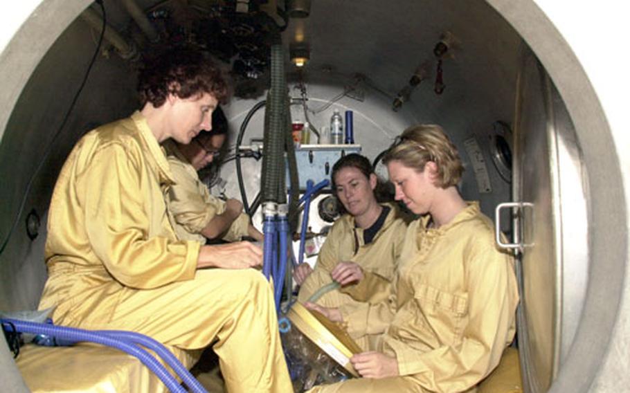 Members of the 18th Wing Physiological Flight’s dive team test their hyperbaric chamber during a readiness exercise Wednesday. From left: Dr. Celest Blanken, Dr. Wendy Tong, Staff Sgt. Stacy Reichert and Staff Sgt. Kristin Hoffman.