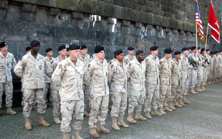 Members of the 9th Engineer Battalion stand in front of the ruins of the famed Remagen, Germany, bridge Friday during a noncommissioned officer induction ceremony.