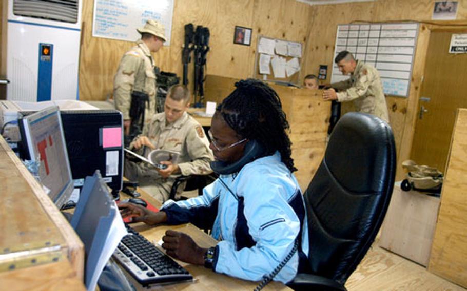 Karen Harris answers the phone at “Catfish Air” Task Force Warfighter Space-A operations at Logistics Support Area Anaconda in Iraq, working to get passengers manifested on space-available flights.