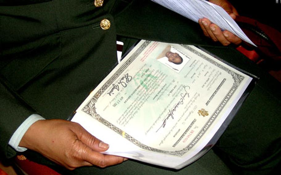 Spc. Jenny Elisabeth Haynes of the Southern European Task Force in Vicenza, Italy, holds her naturalization certificate after a naturalization ceremony. Haynes had been a citizen of the Netherlands.