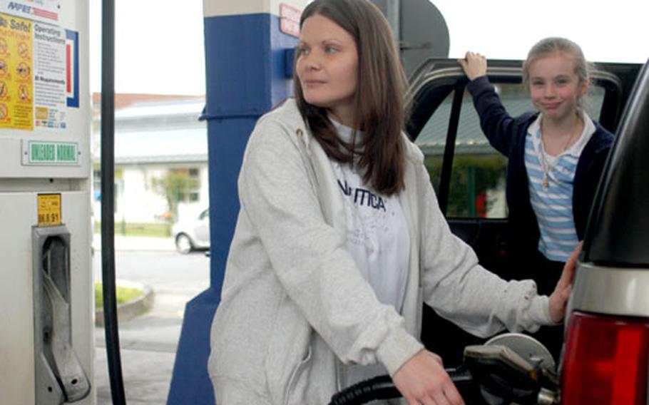 Mindy Palmquist and her daughter, Celeste, 6, add about $10 of gas to their car Thursday on the Lincoln Village Car Care Center gas station in Darmstadt, Germany. Palmquist was getting as much gas as she could before prices rise about 20 cents per gallon on May 1.