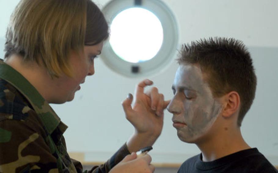 Staff Sgt. Emmilee Fernet from the 31st Medical Group paints the face of sophomore Levi McCracken during an alcohol awareness event Thursday at Aviano High School, Italy.