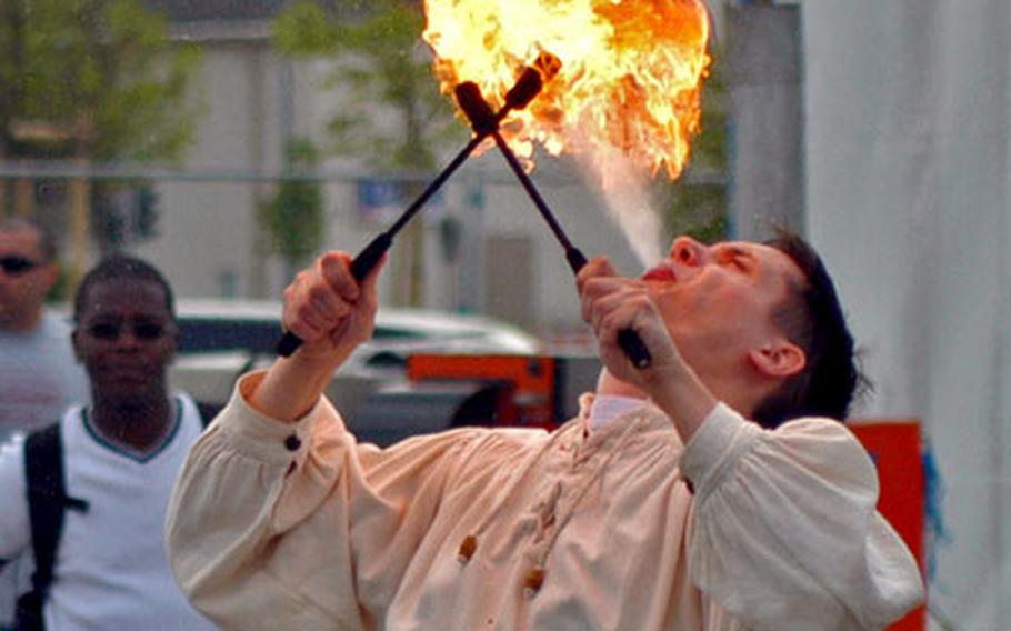 An entertainer makes a fireball for partygoers Thursday — appropriately enough near a smoking area.