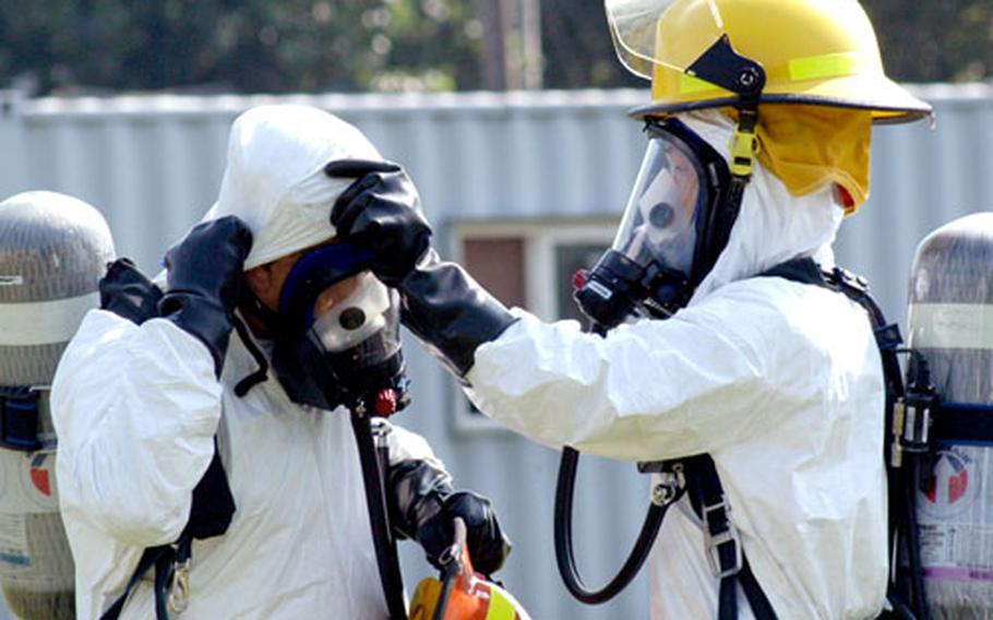 Firefighters from the U.S. Army&#39;s fire station at Camp Walker in Taegu, South Korea, check each other&#39;s equipment before responding to a simulated biological attack at nearby Camp George last July.