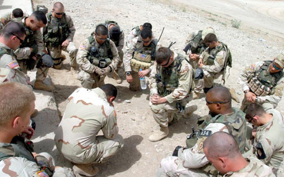 Soldiers with 3rd Platoon, Company A, 1st Battalion, 24th Infantry Regiment, kneel in prayer Wednesday morning before heading out on a combat mission.