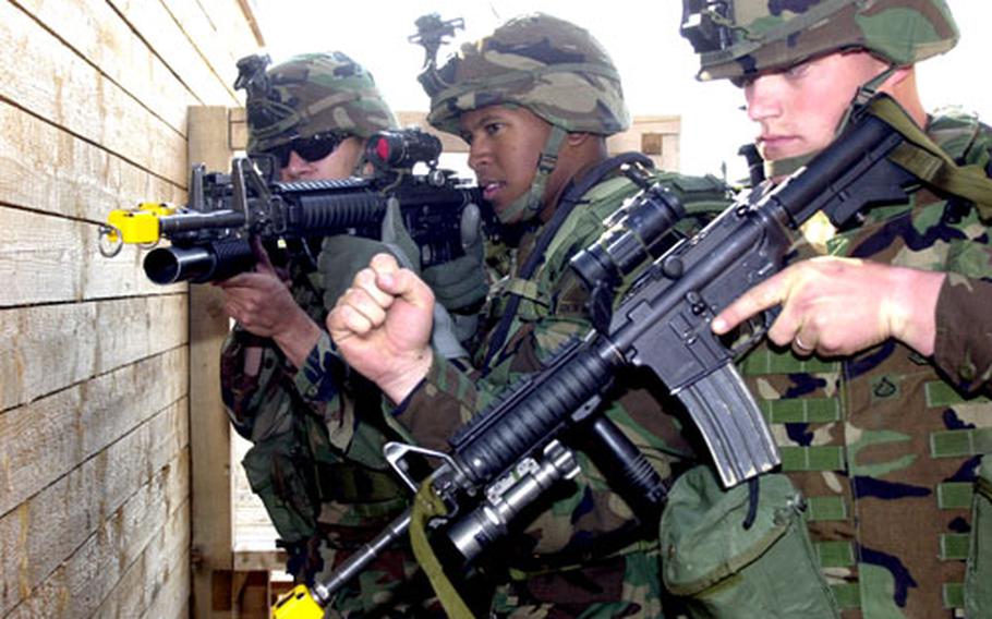 Pfc. Matthew Erickson, 22, from Othello, Wash., and Company B of the 2nd Battalion, 6th Infantry Regiment, prepares to break open the door to Baumholder’s new shoot house during a demonstration Friday. Ready to go in with Erickson are Spc. Willis Sanft, 18, from Waco, Texas, center, and Spc. Jesse Roderiguez, 24, from Chicago, Ill. They are members of the same unit.