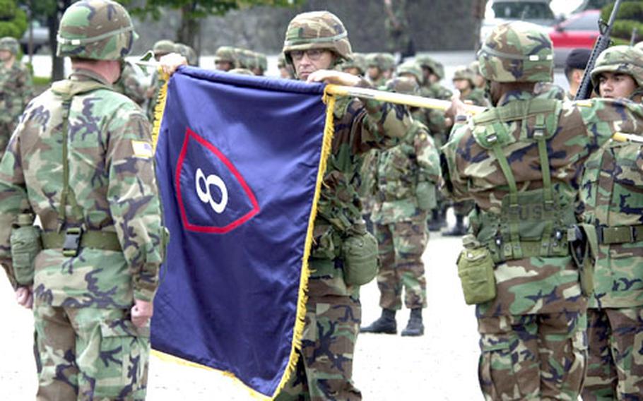 Command Sgt. Maj. Carlos A. Martinez-Rivera prepares the 8th Personnel Command’s colors to be cased during an inactivation ceremony Wednesday at Yongsan Garrison, South Korea. His commander, Col. Michael J. Harris, is holding the colors while 8th Army commander Lt. Gen. Charles Campbell, left, observes.