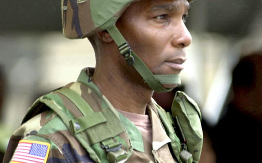 Col. Michael J. Harris, commander of the 8th Personnel Command, observes his troops as they stand in formation.