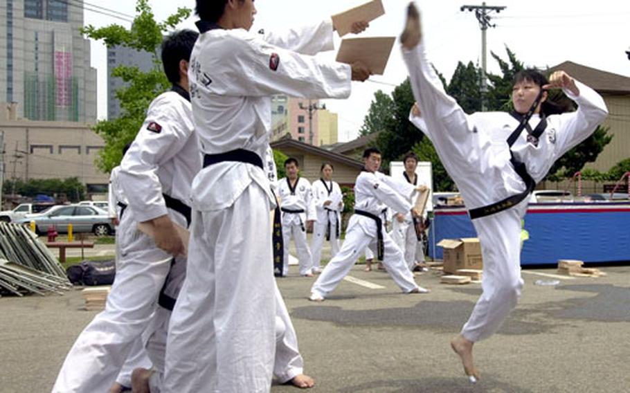 Members of the Kokkiwon University tae kwon do demonstration team warm up Friday before a performance.